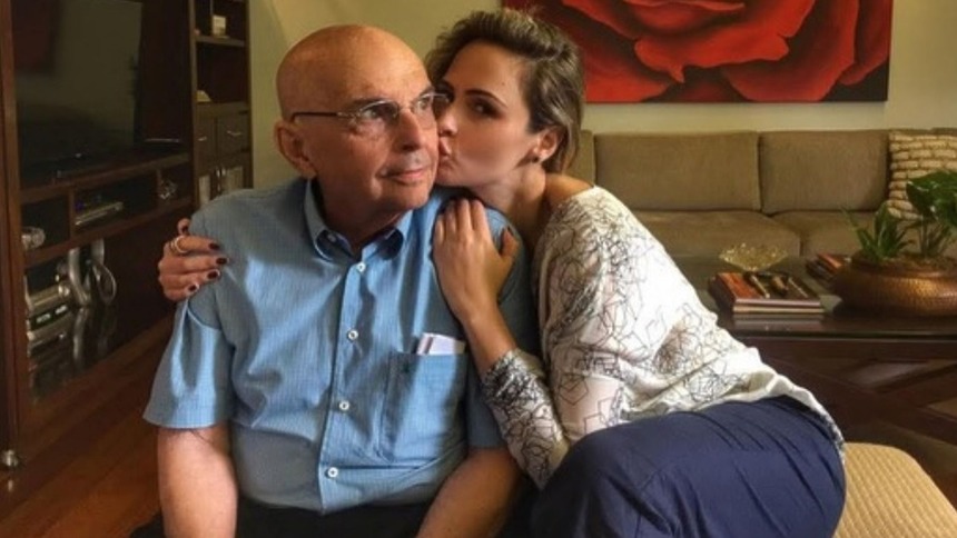 Ana Paula Renault dando um beijo no rosto do pai, já idoso, em foto posada