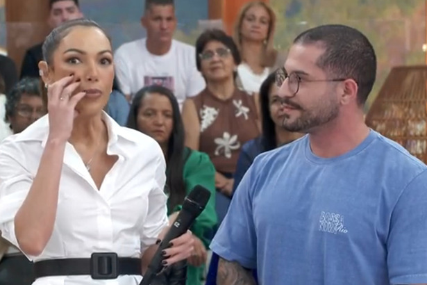 Patrícia Poeta mostrando algo no rosto, ao lado de um convidado no Encontro