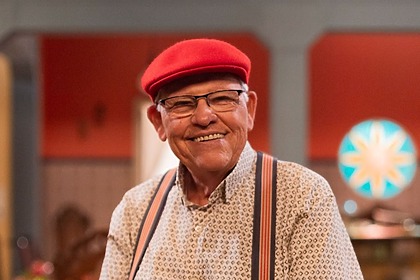 Silvio Mattos de chapéu vermelho no cenário da Família Paraíso do Multishow