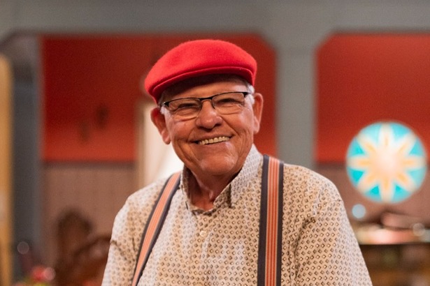 Silvio Mattos de chapéu vermelho no cenário da Família Paraíso do Multishow
