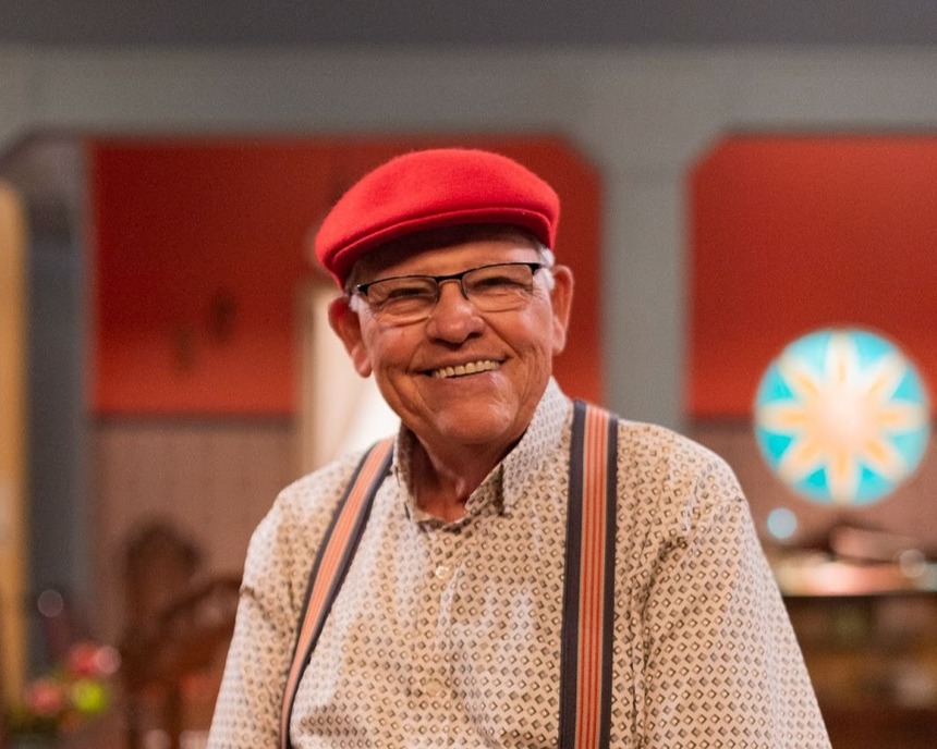Silvio Mattos de chapéu vermelho no cenário da Família Paraíso do Multishow