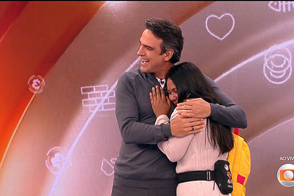 Tadeu Schmidt abraçando Chaiany no cenário do BBB 26 após a eliminação