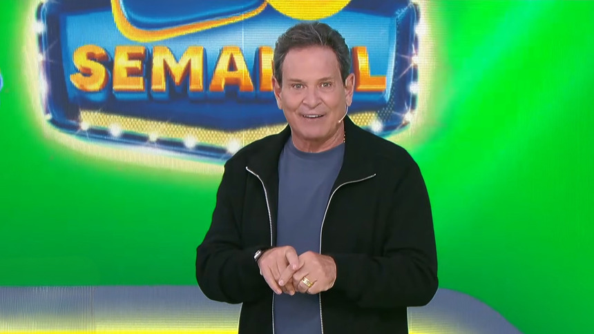Luis Ricardo sorridente em frente ao telão com o bilhete verde da Tele Sena Semanal edição 98