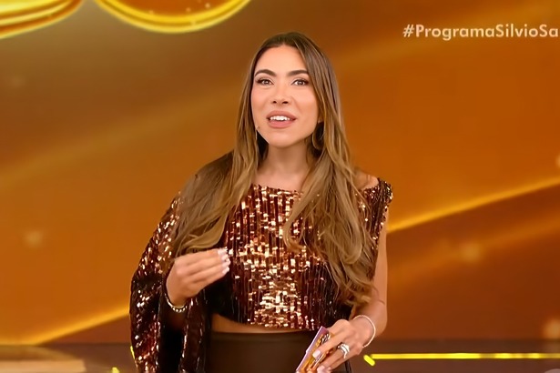 Patricia Poeta sorridente segurando bilhete da Tele Sena de Páscoa 2026 no palco do Programa Silvio Santos