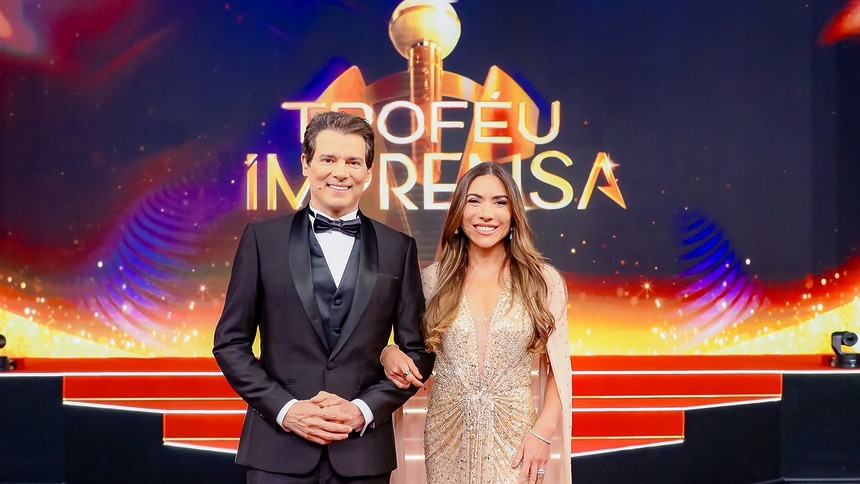 Celso Portiolli ao lado de Patricia Abravanel sorridentes no centro do palco do Troféu Imprensa 2026