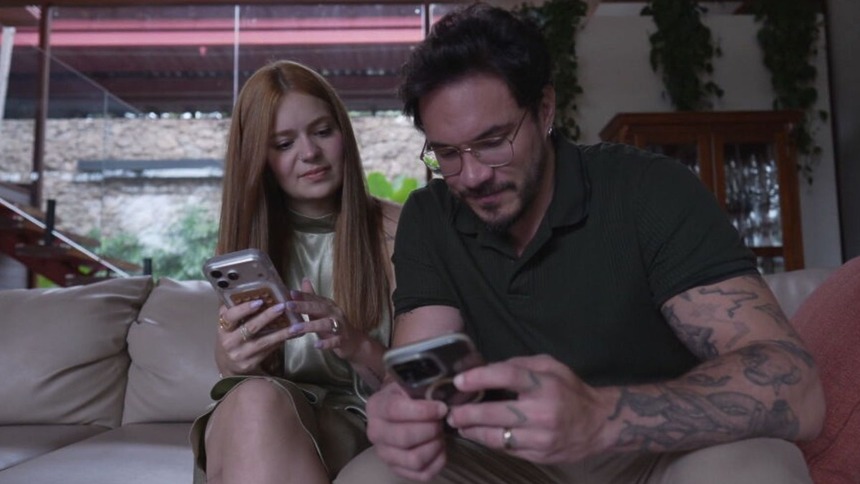 Viih Tube e Eliezer, mexendo no celular, em trecho do Globo Repórter