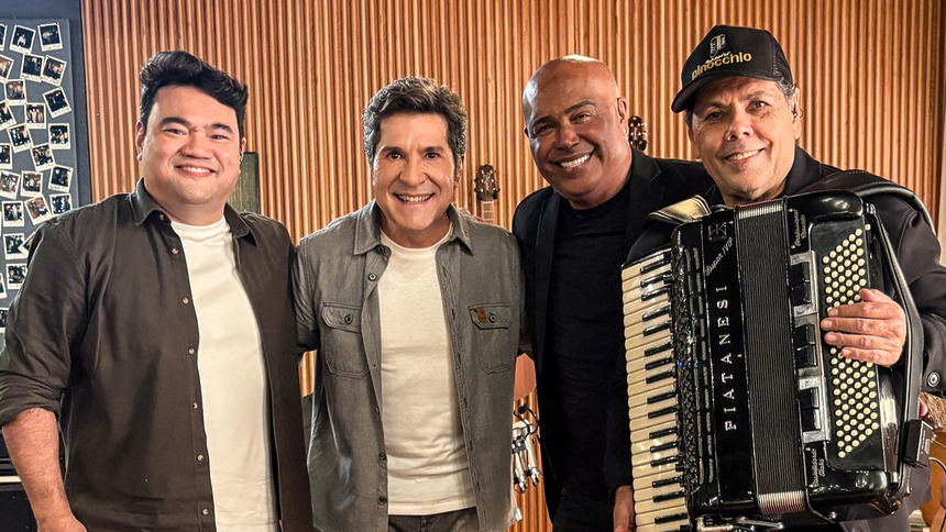 Daniel abraça Maestro Pinocchio, Ivan Miyazato e Rick Sollo. Todos estão em pé e sorridentes no centro do cenário do Viver Sertanejo