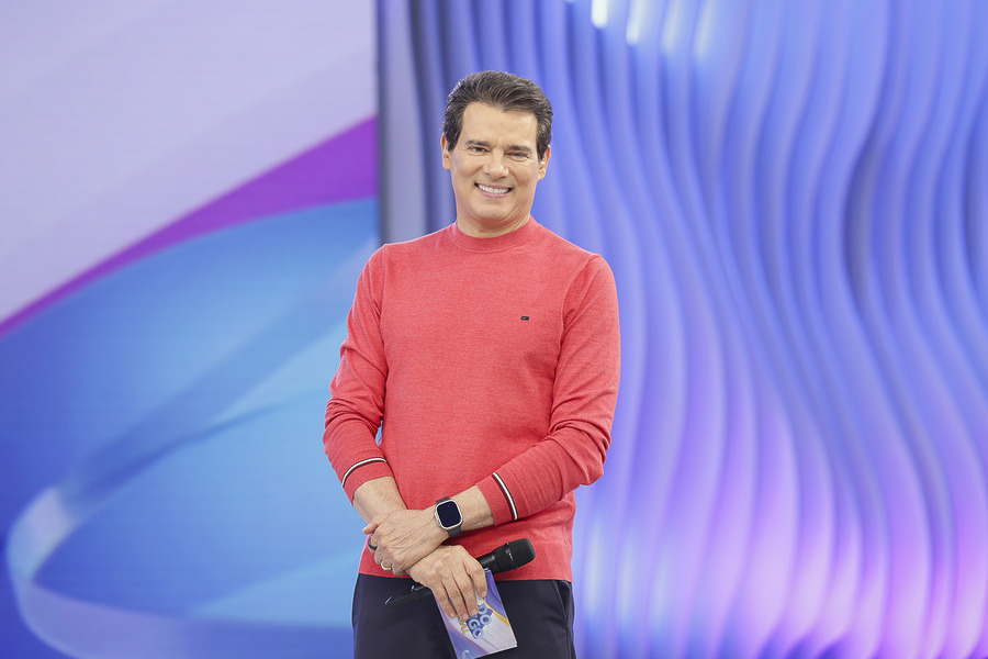 Celso Portiolli em pé e sorrindo no palco do programa
