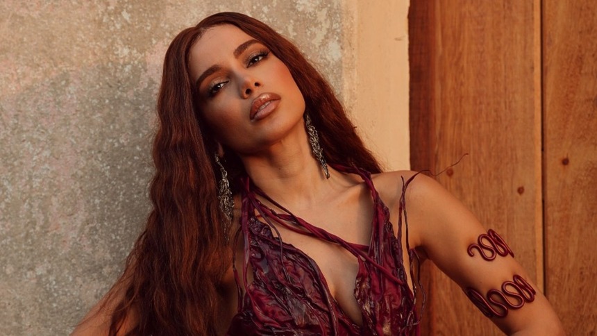 Anitta em foto posada, com o rosto deitado