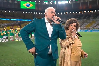 Belo e Alcione cantando o Hino Nacional no Maracanã, antes do amistoso da Seleção Brasileira