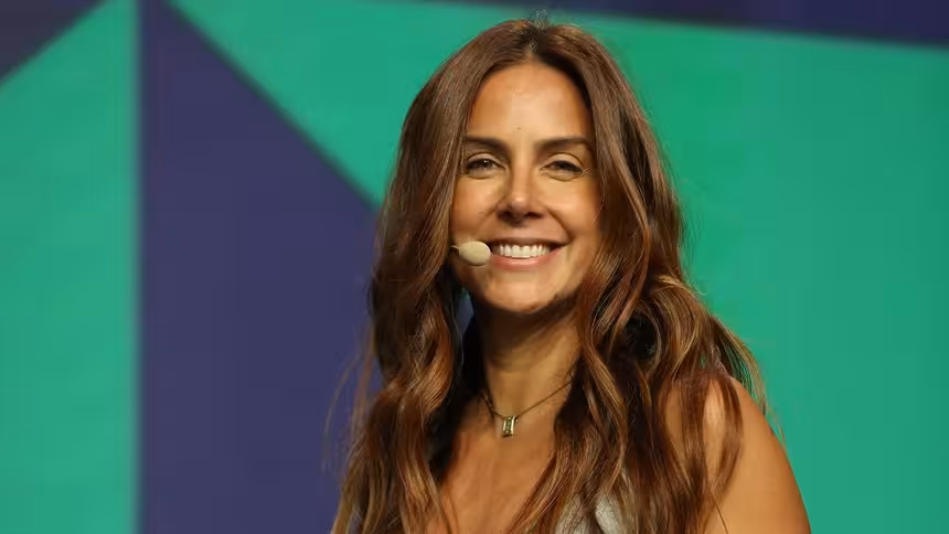 Carol Barcellos sorridente no palco da Coletiva de Imprensa da Copa Do Mundo do SBT