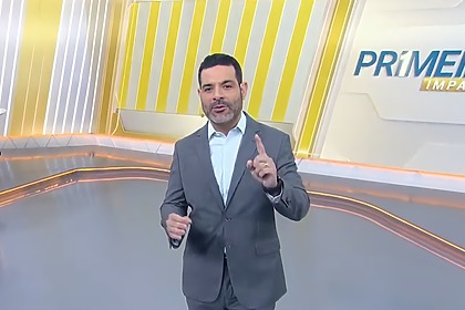 Darlisson Dutra levanta o dedo apontando para o alto no cenário do Primeiro Impacto