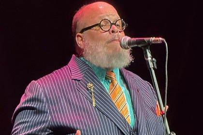 Ed Motta de terno cantando em um show