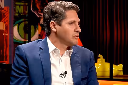 Edmílson, ex-jogador, de blazer, em trecho de entrevista
