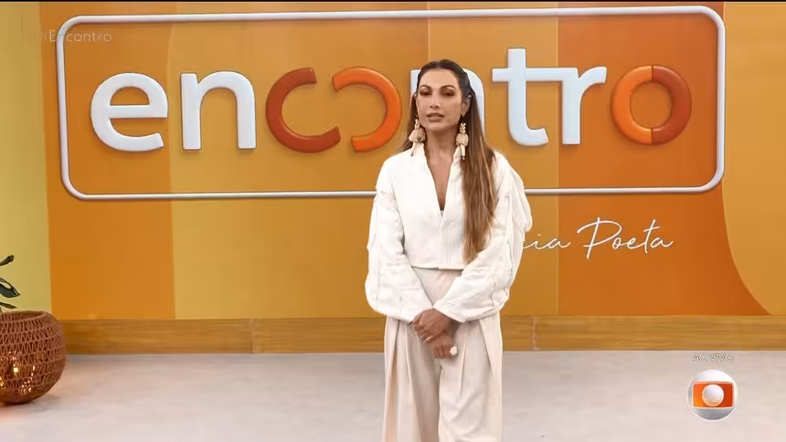 Patrícia Poeta em frente ao telão com o novo logo do programa Encontro que agora predomina os tons de amarelo e salmon