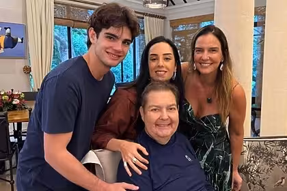 Faustão com os filhos Rodrigo e Lara, sorrindo, em foto posada