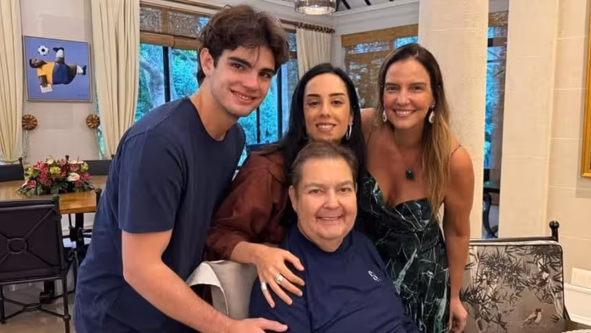 Faustão com os filhos Rodrigo e Lara, sorrindo, em foto posada
