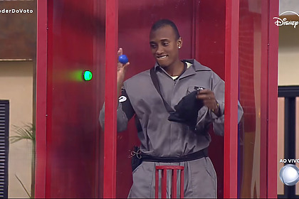 JP segura bola azul na cabina vermelha da Prova do Poder do Voto da Casa do Patrão