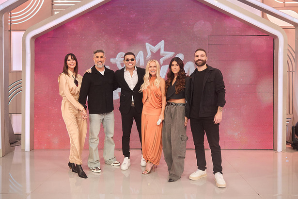 Suzana Gullo, Marcos Mion, Tierry, Eliana, Luana Zucoloto e Yan Pinheiro no palco do 'Em Família com Eliana'. Todos estão em pé sorridentes e abraçados em frente ao telão