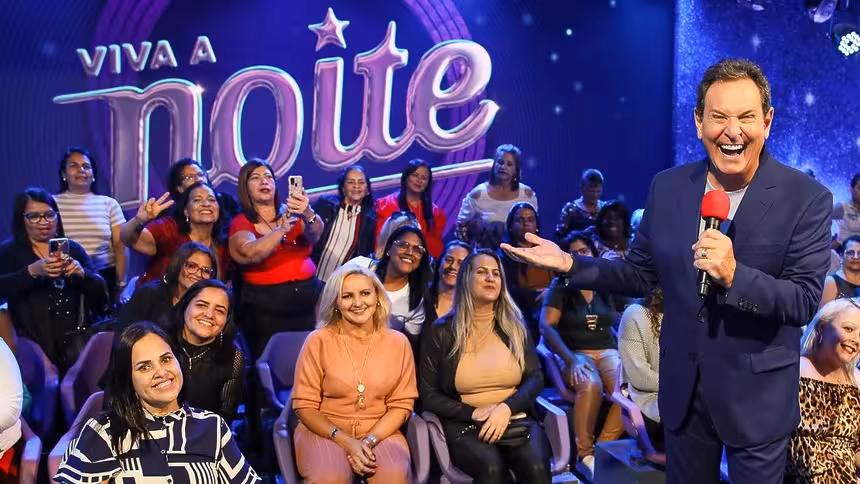 Luis Ricardo sorridente no cenário do Viva a Noite