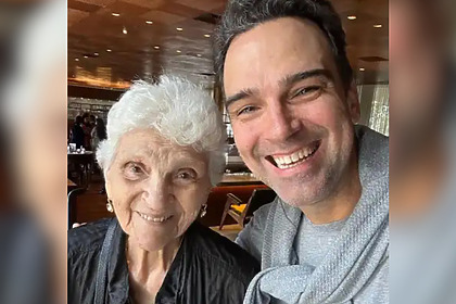 Dona Janira sorridente ao lado de Tadeu Schmidt em um restaurante