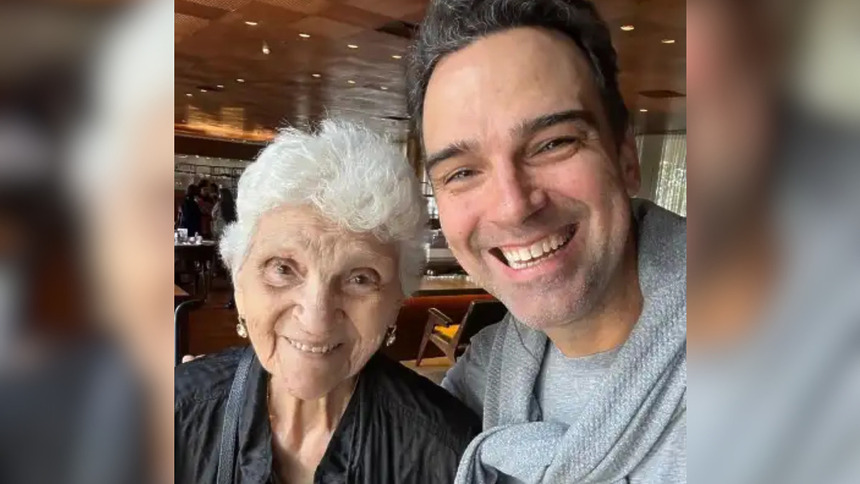 Dona Janira sorridente ao lado de Tadeu Schmidt em um restaurante