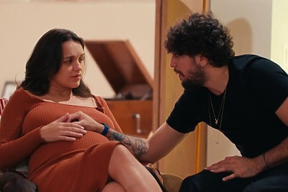 Nattan E Rafa Kalimann emocionados, com o cantor tendo a mão sobre a barriga da influenciadora