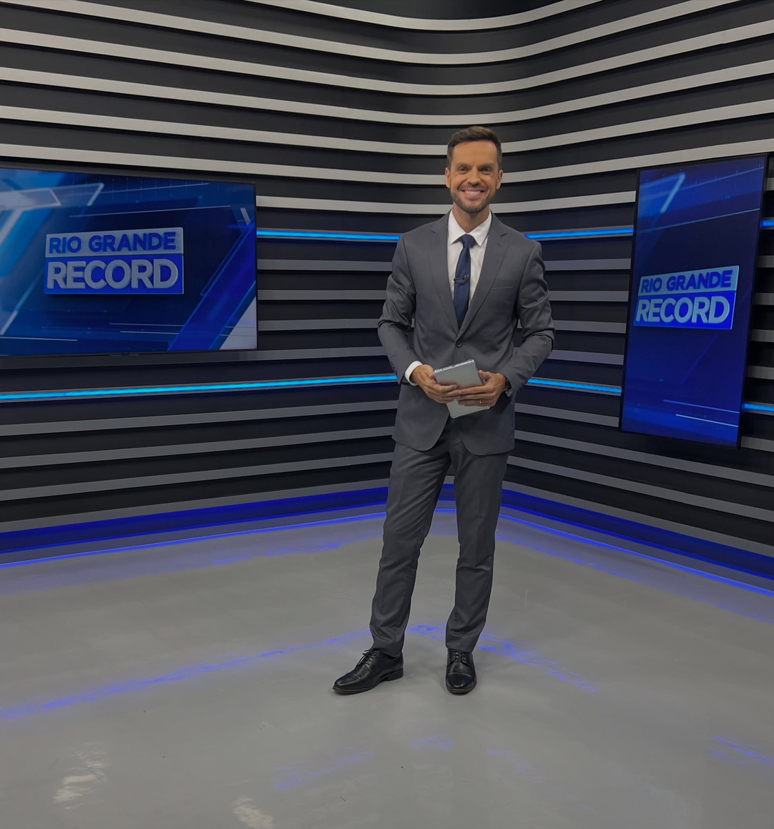 Léo Saballa Jr. sorridente e em pé no centro do novo cenário do Rio Grande RECORD