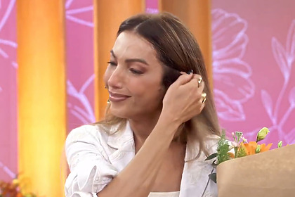 Patrícia Poeta com buquê de flores na mão, emocionada, após mensagem do filho no Encontro
