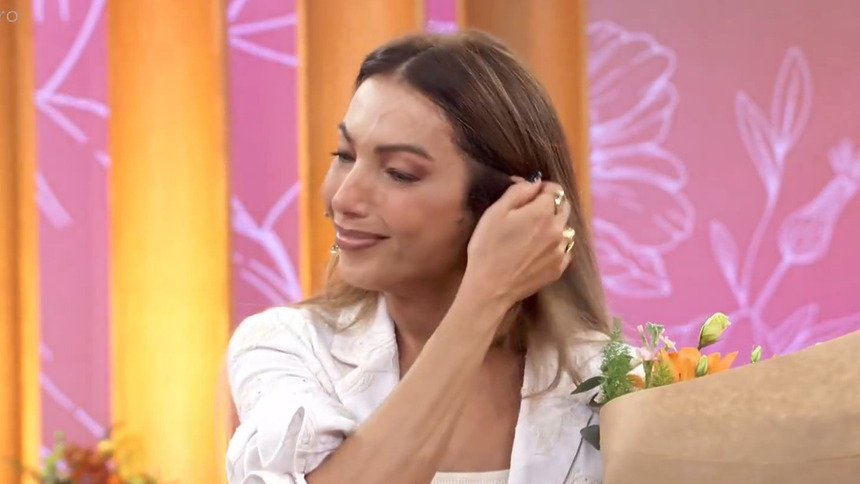 Patrícia Poeta com buquê de flores na mão, emocionada, após mensagem do filho no Encontro