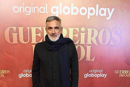Rogério Gomes em frente ao painel com logo da novela Guerreiros do Sol