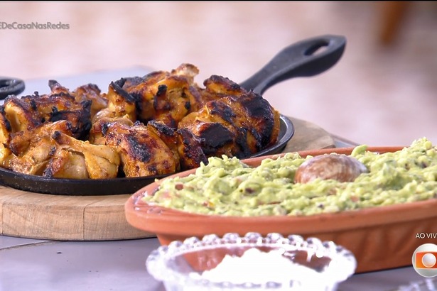 Sobrecoxa com iogurte na churrasqueira, molho tzatziki e guacamole do thiago oliveira em cima da mesa do é de casa