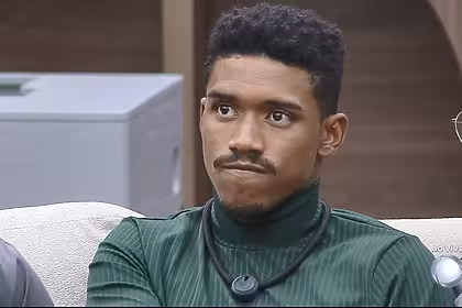 Thiago com semblante triste no sofá da Casa Do Patrão poucos minutos antes de ser eliminado. Ele veste uma camisa verde