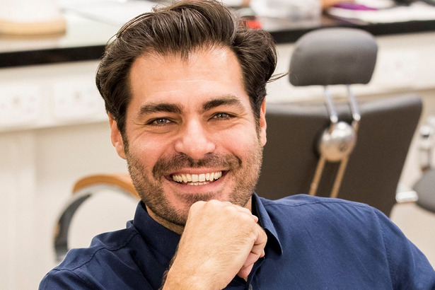 Thiago Lacerda sorridente com a mão no queixo