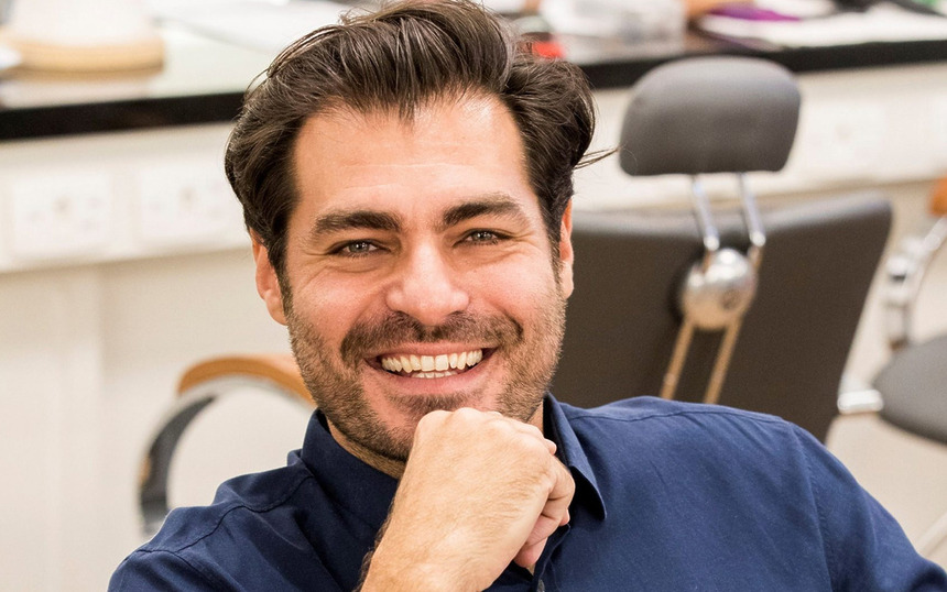 Thiago Lacerda sorridente com a mão no queixo
