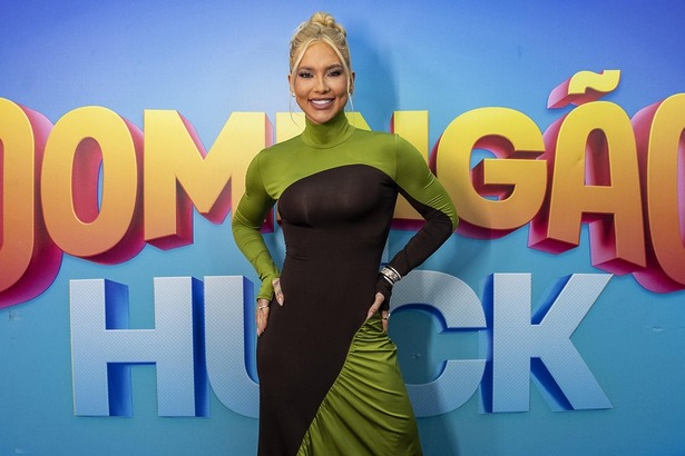 Virginia Fonseca em frente ao painel com o logo do Domingão Com Huck