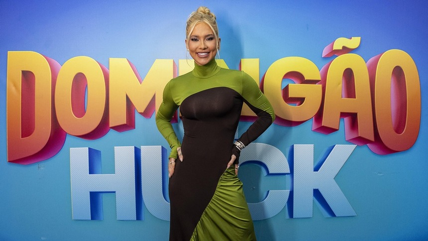 Virginia Fonseca em frente ao painel com o logo do Domingão Com Huck