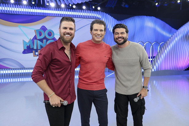 Celso Portiolli abraça Zé Neto E Cristiano no palco do Domingo Legal, ambos estão bem felizes e sorridentes