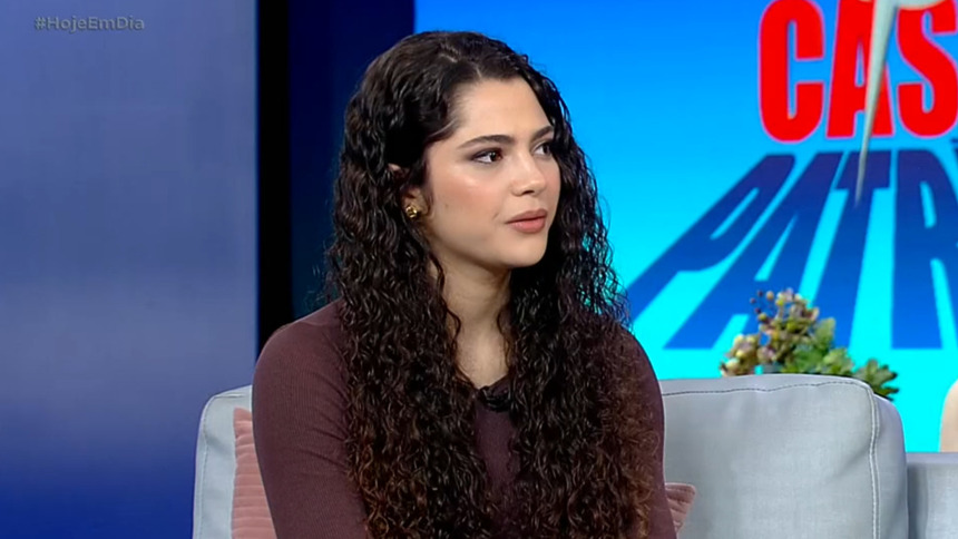 Andressa, de blusa escura, sentada no sofá do Hoje em Dia após eliminação na Casa do Patrão