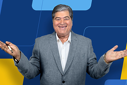Datena sorrindo e de abraços abertos na TV Brasil