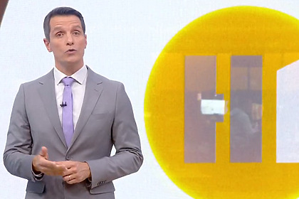 Giba Bergamim em frente ao telão no estúdio do Hora 1