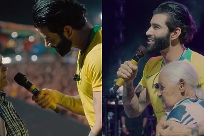 Gusttavo Lima abraçando uma fã idosa no palco em trecho de show no São João de Carpina