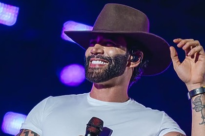 Gusttavo Lima com chapéu em trecho de show