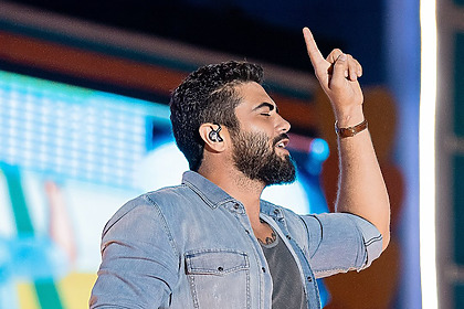 Henrique, da dupla com Juliano, aponta o dedo para o alto no palco do show de Petrolina