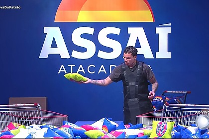 Vivão conta as almofadas e as coloca no carrinho de compras da Prova Do Patrão em frente ao logo do Assaí na Casa do Patrão
