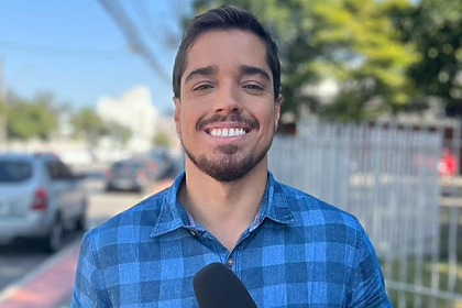 Caíque Verli posando com o microfone da TV Gazeta