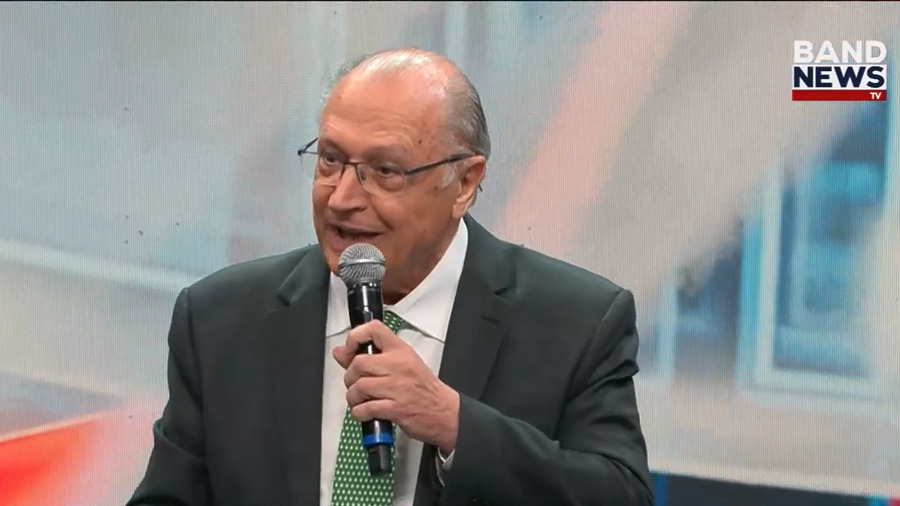 Vice-presidente da República Geraldo Alckmin segura microfone e discursa sorridente no lançamento da nova BandNews TV
