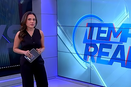 Marcia Dantas veste preto e chora no centro do cenário do Tempo Real na Jovem Pan