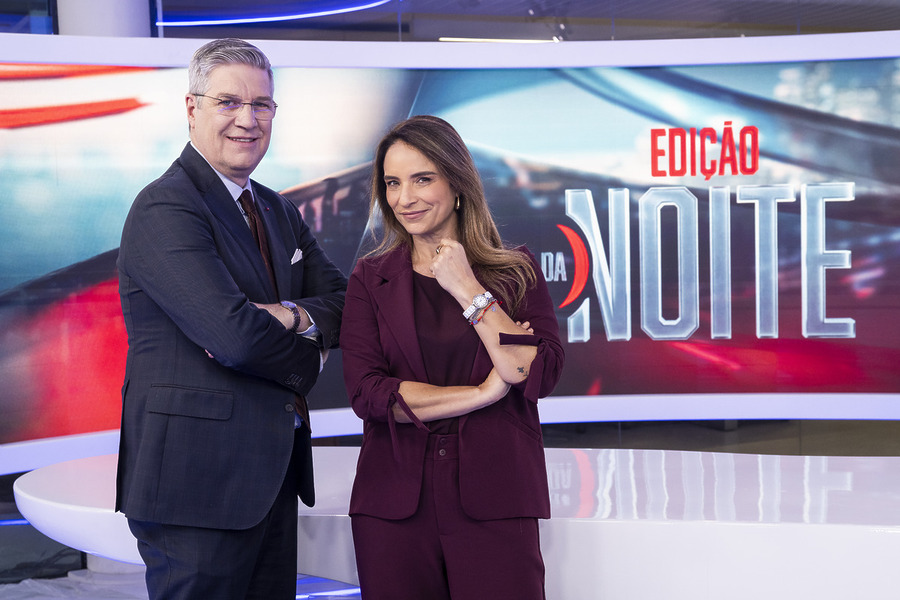 Felipe Vieira e Veruska Donato sorridentes e lado a lado em pé na frente da bancada do novo Edição da Noite