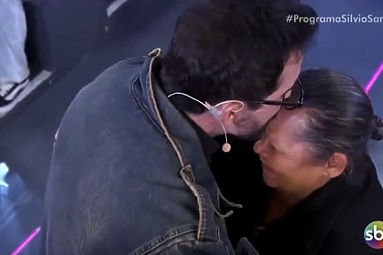 Padre Fábio de Melo beijando senhora após dar prêmio para no Programa Silvio Santos